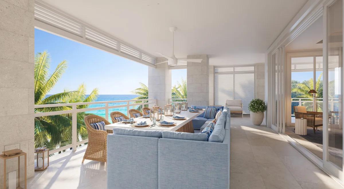 a living room opening to a dining terrace and the sea