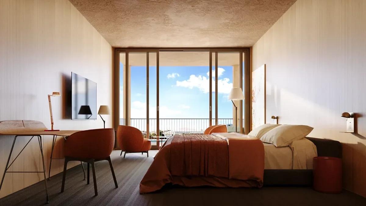 A timber-lined bedroom in terracotta tones with a writing desk and sliding doors opening to a sea view