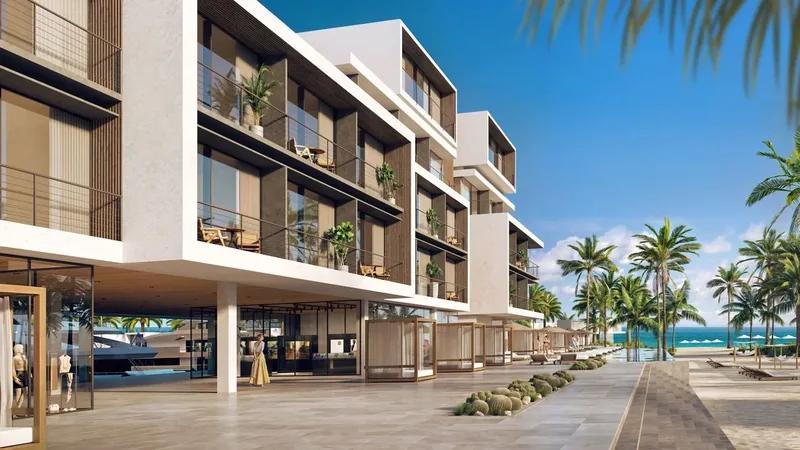 Artist’s rendering of a row of apartment buildings with planted balconies facing a beach