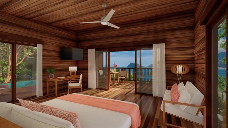 A timber-lined bedroom with a coral throw, doors open to a balcony and the sea