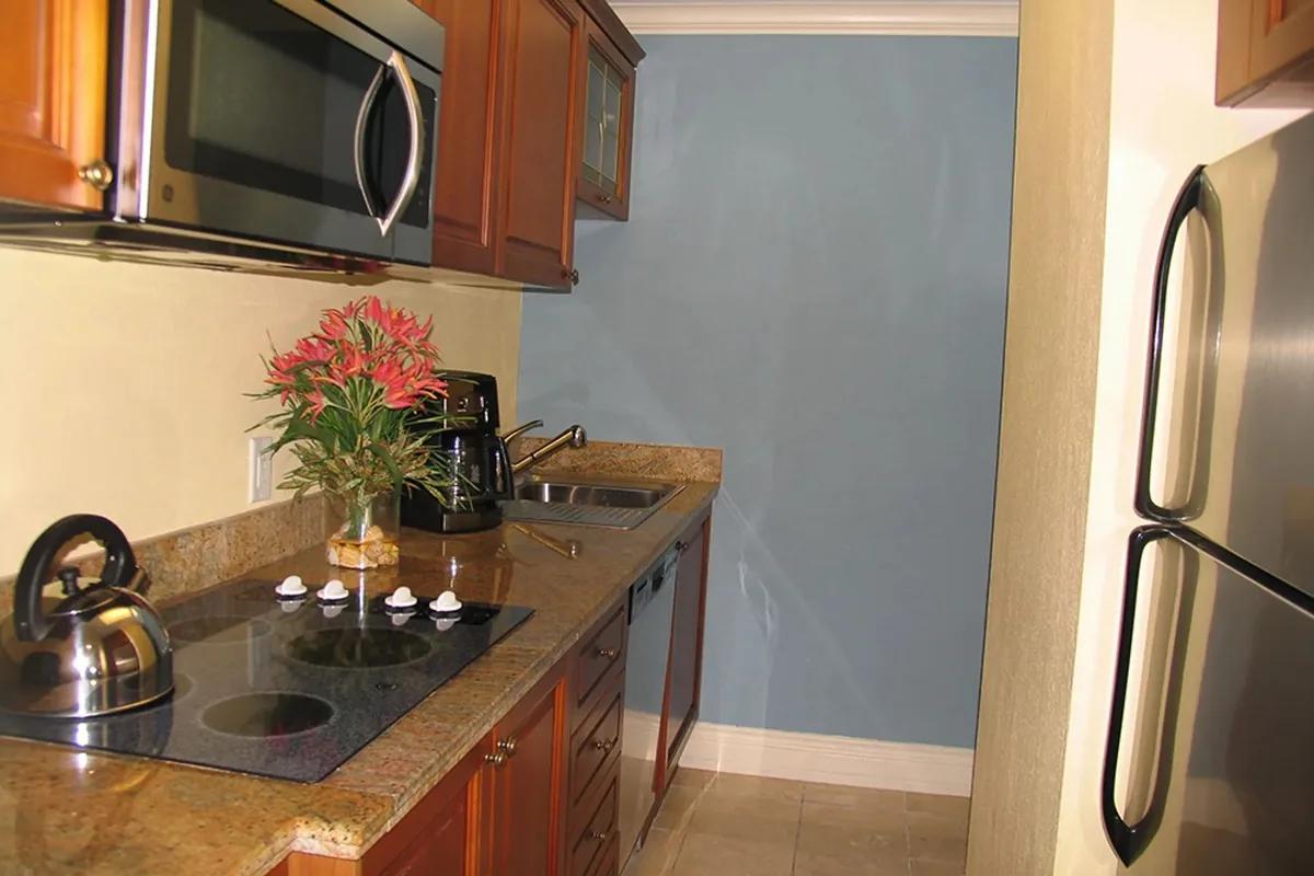 The kitchen, with granite counters, cooktop and full-size refrigerator