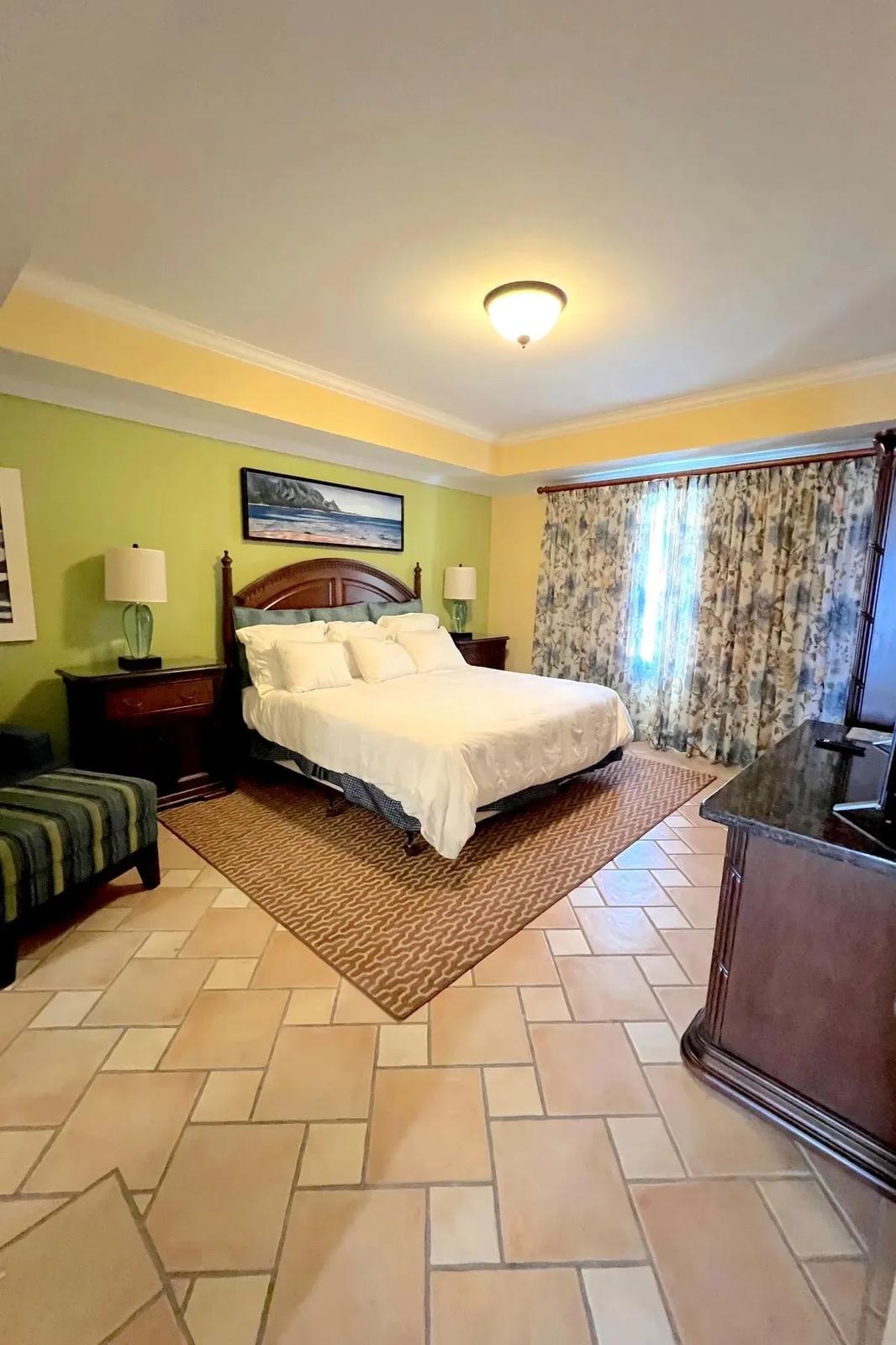 The bedroom, with a king bed and tiled floor