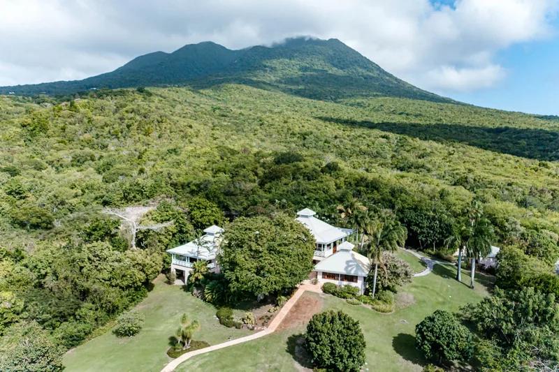 Nevis Peak rising above wooded slopes, a white house among the trees below