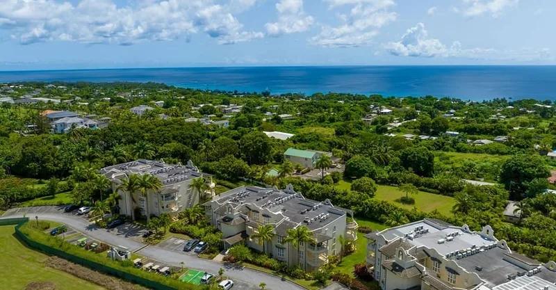 Low apartment blocks among mature trees at Royal Westmoreland, the sea beyond