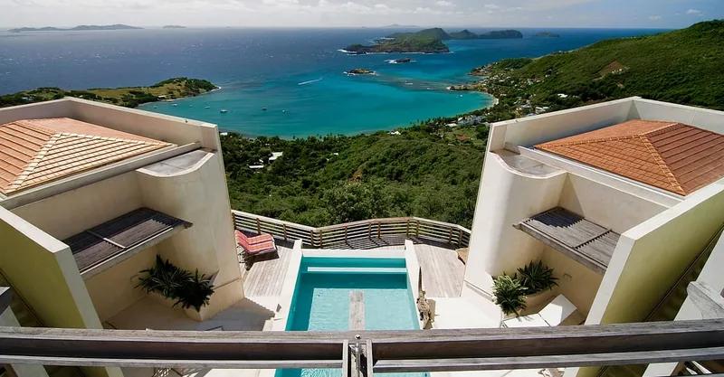 Terracotta-roofed villas above a pool, looking down over a sheltered bay