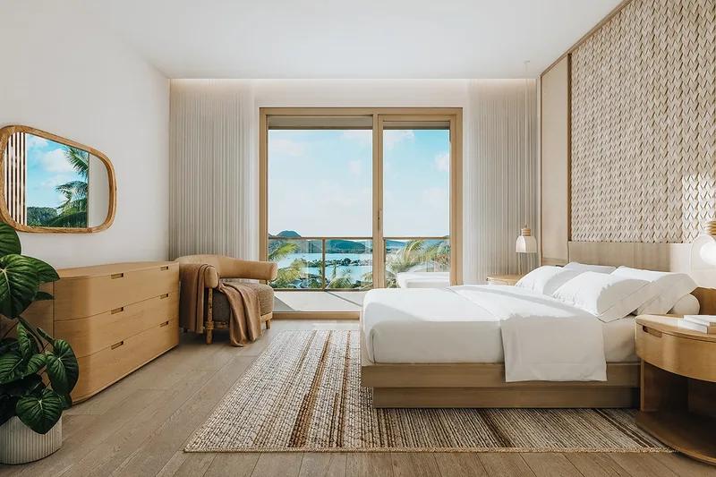 A bedroom with a woven wall panel and a window framing the sea
