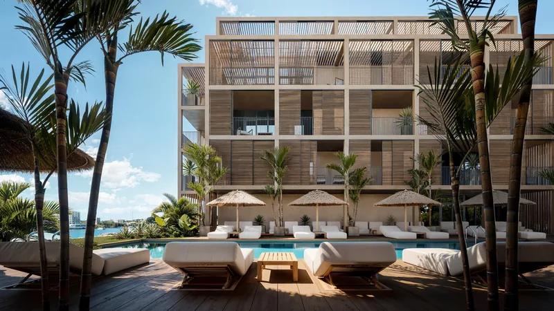 a timber-screened apartment building above a row of beach beds and parasols