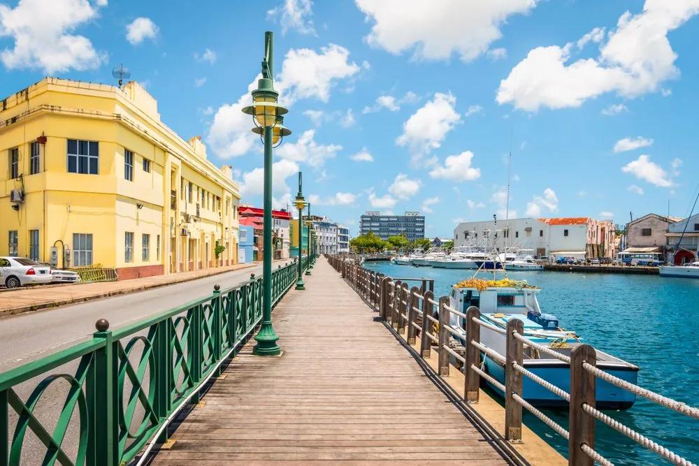 The boardwalk along the Bridgetown careenage, a yellow colonial building and moored boats