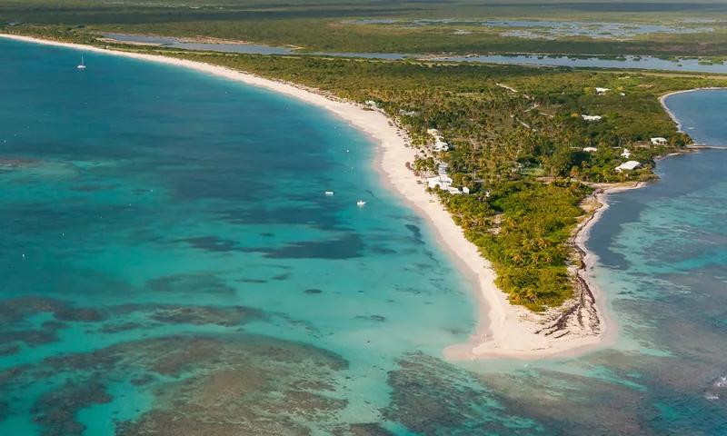 A long low sandspit running out into reef shallows, seen from the air
