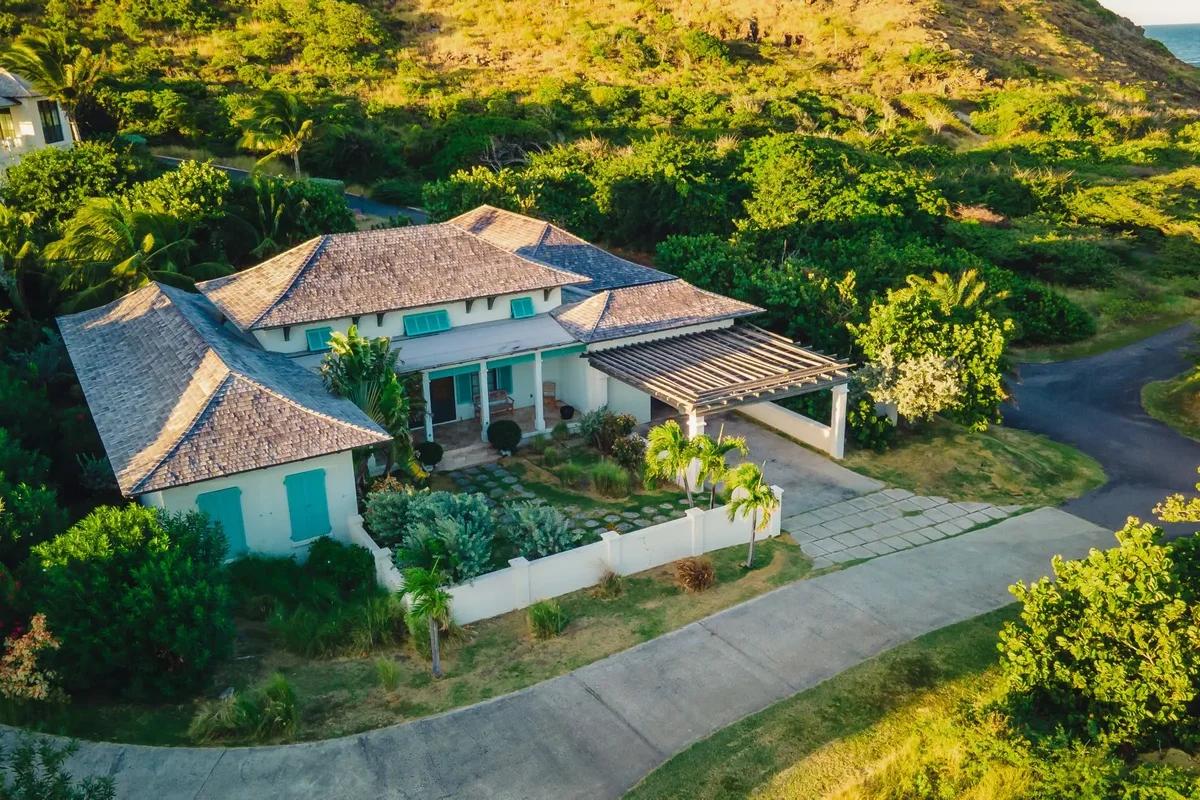 A hip-roofed villa set into a green hillside at Sandy Bank Bay, St Kitts, seen from the air