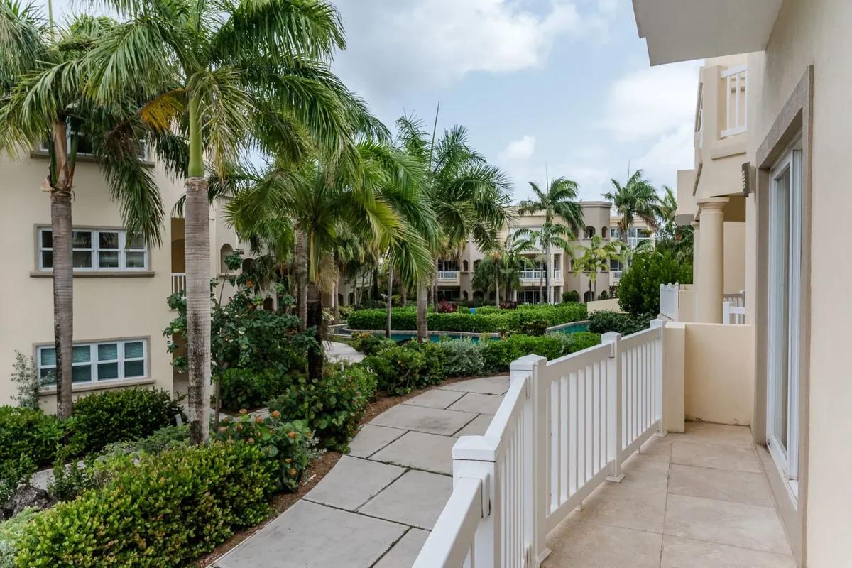 A balcony looking over palms and lawns to low apartment buildings